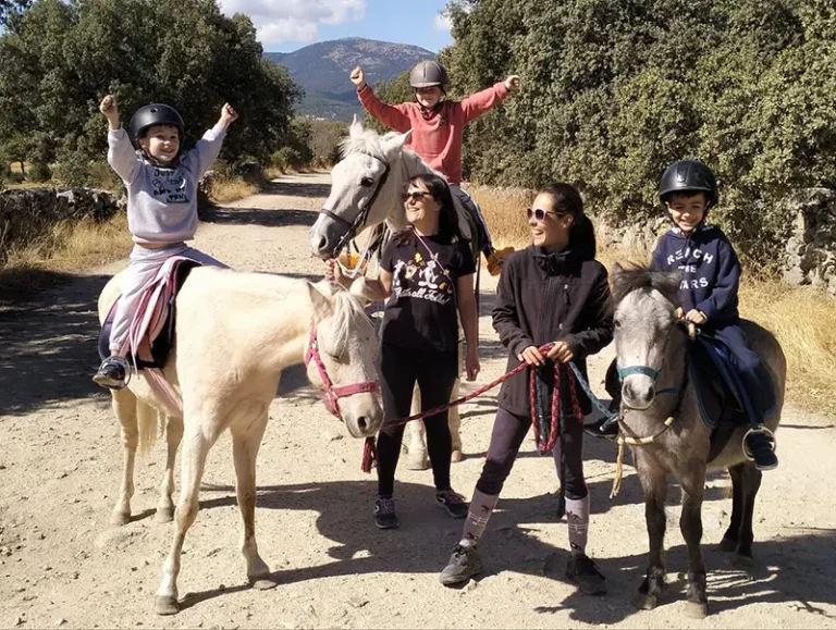 Grupo de niños disfrutando de un paseo en poni con monitoras en la Sierra de Guadarrama.